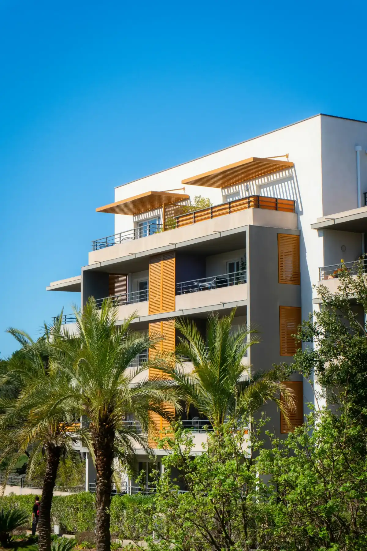 Modern apartment complex exterior with landscaped grounds and parking